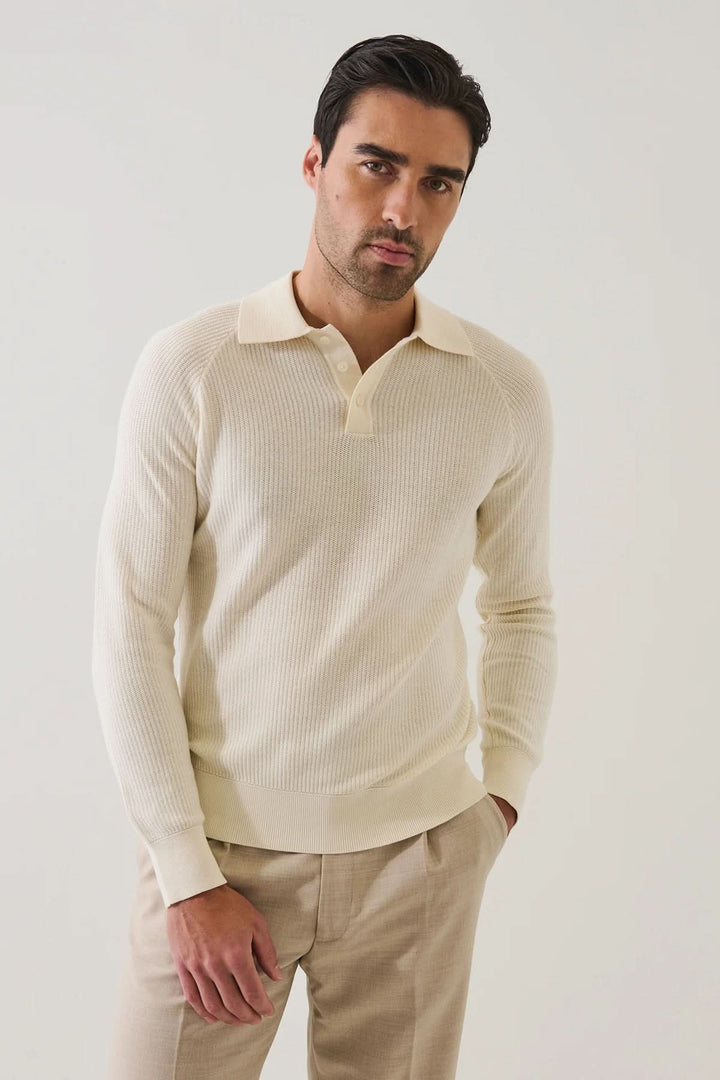 Homme portant un POLO EN MAILLE CÔTELÉE beige avec manches raglan, élégance et confort, style moderne et décontracté.