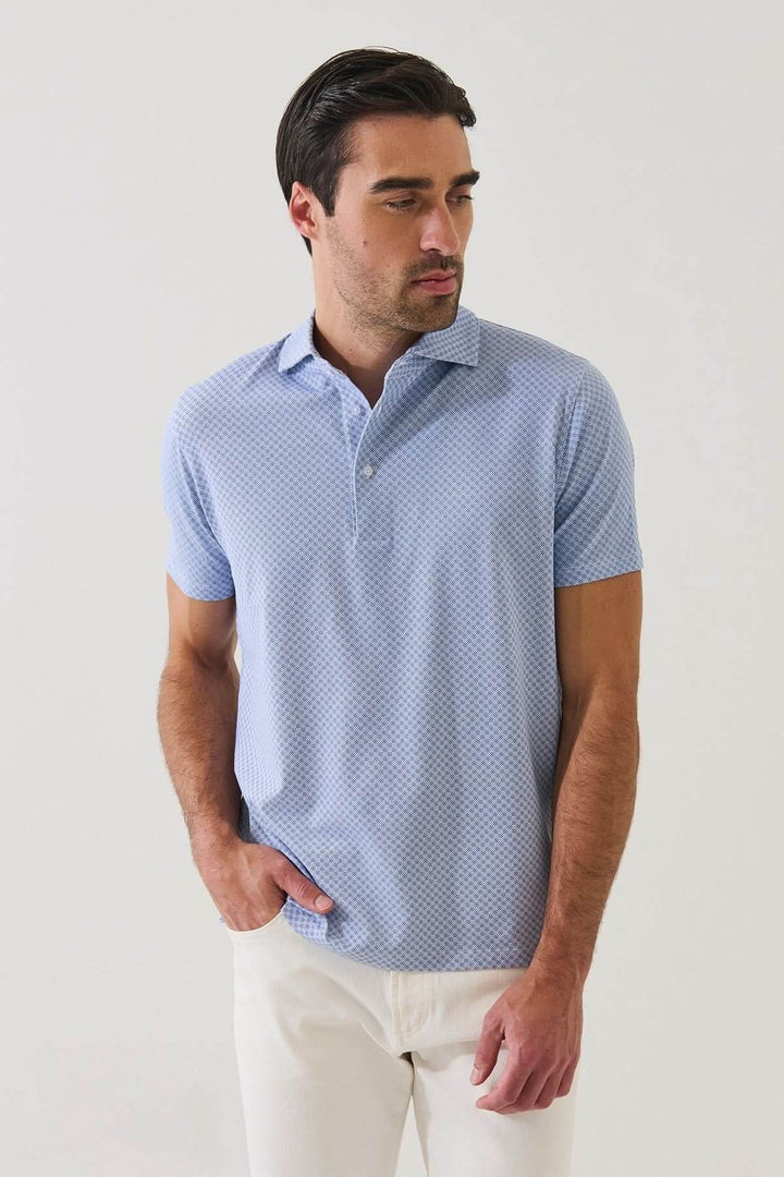Homme portant un POLO IMPRIMÉ GÉOMÉTRIQUE À MANCHES COURTES bleu, motif subtil, tissu extensible, idéal pour un style élégant en été.