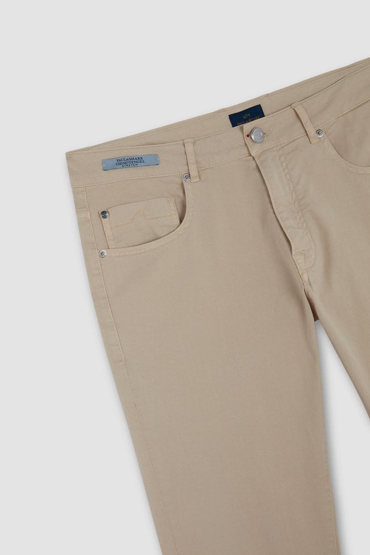 Pantalon chino beige en coton stretch, coupe ajustée, essentiel du vestiaire masculin.