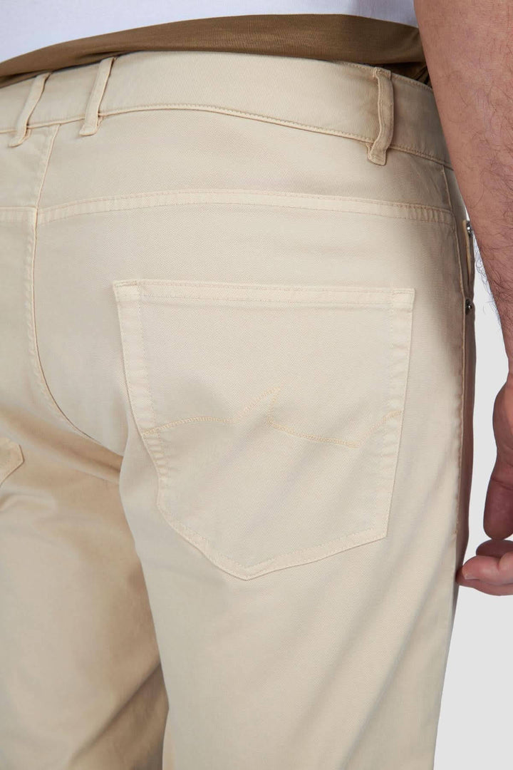 Détail arrière d'un pantalon chino beige en coton, montrant la coupe ajustée et la poche.