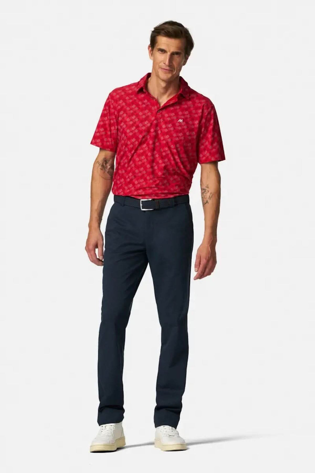 Homme en pantalon Bonn, coupe droite, taille élastiquée, avec un polo rouge à motifs, style décontracté et élégant.
