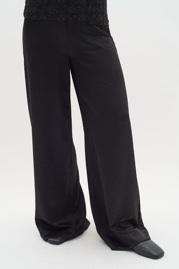 Pantalon Didra en tissu satiné noir, coupe droite et fluide pour un style chic et moderne.