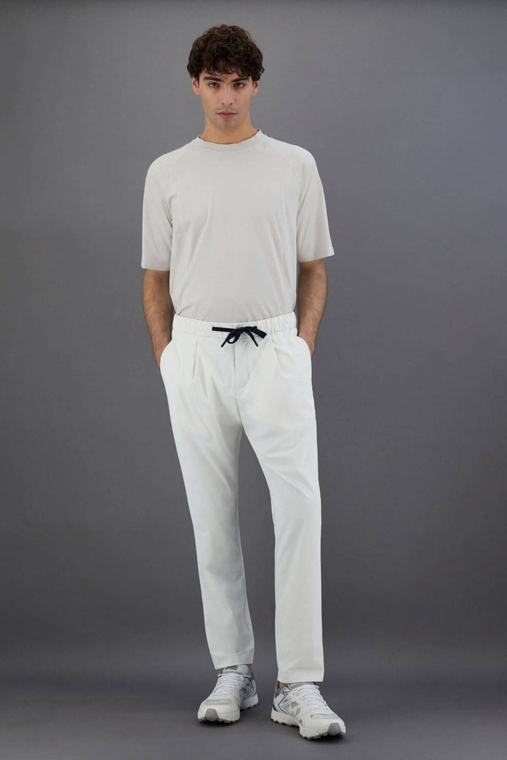 Homme portant un pantalon Laminar en nylon, coupe régulière, avec cordon de serrage, look sportif et sophistiqué.
