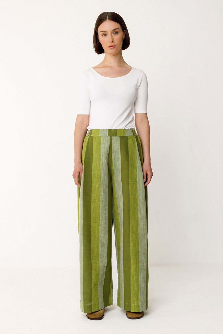 Modèle portant un Pantalon Lur large fluide rayé taille haute en vert avec rayures, coupe élégante et poches latérales.