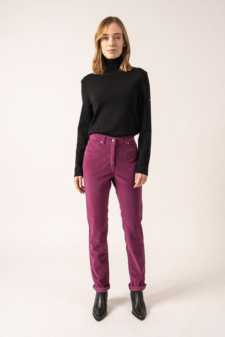 Femme portant le pantalon Mimosa velours taille haute en velours côtelé, associé à un pull noir chic.