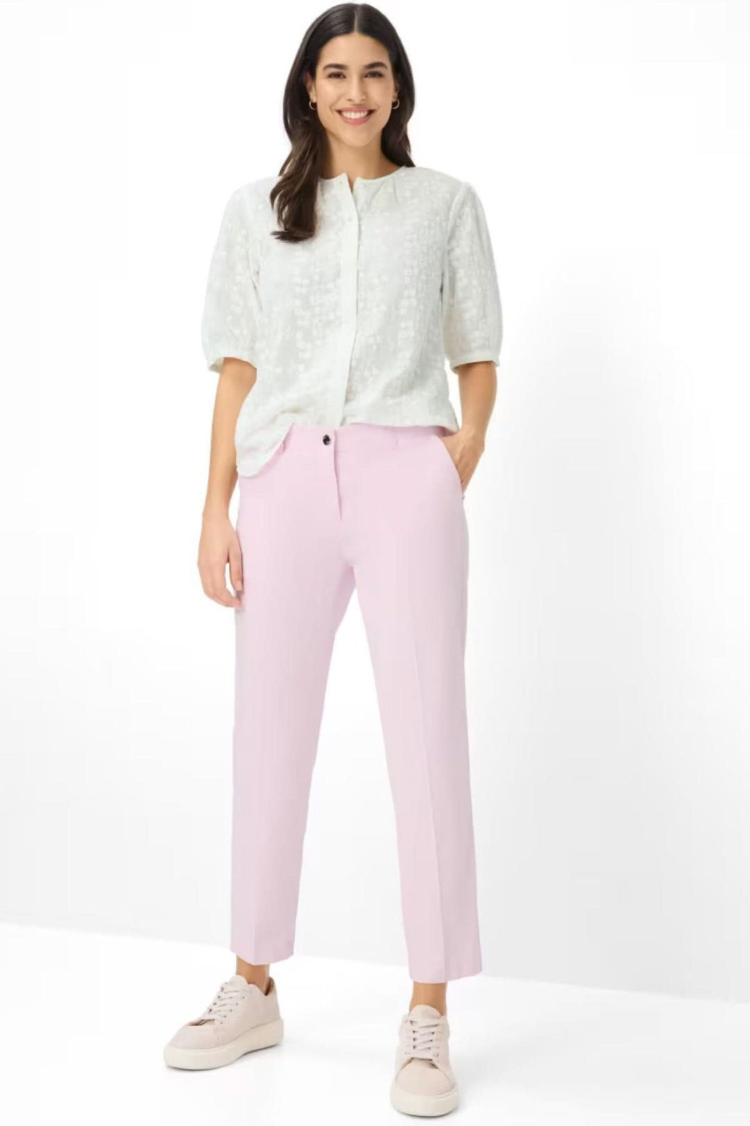 Femme portant un Pantalon Maron à coupe droite et longueur cheville, alliant confort et modernité en rose pastel, avec des poches pratiques.