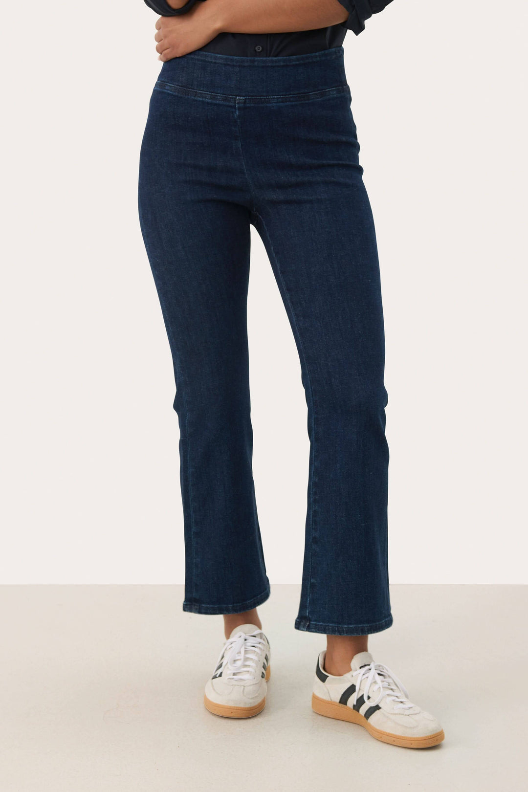 Pantalon Nikela bleu à coupe évasée, taille haute, longueur cheville. Tissu extensible pour confort et allure moderne.