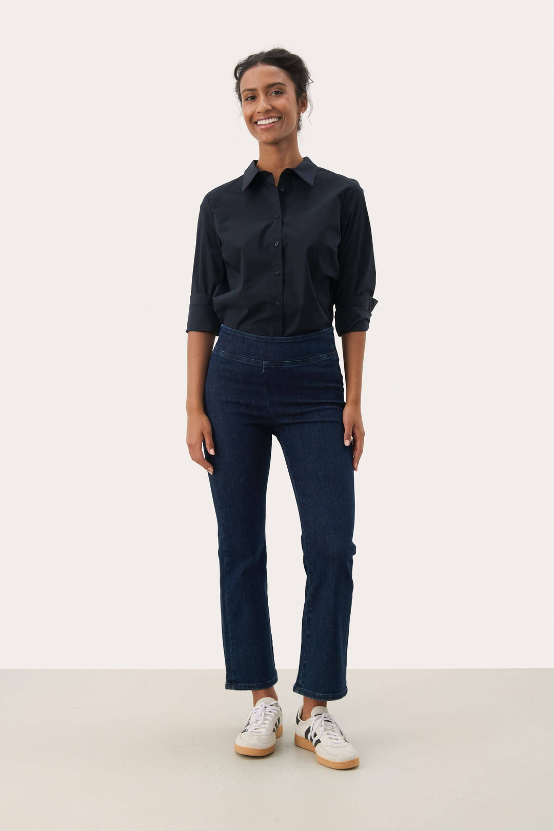 Modèle portant le Pantalon Nikela taille haute avec coupe évasée et tissu extensible pour une allure moderne et confortable.