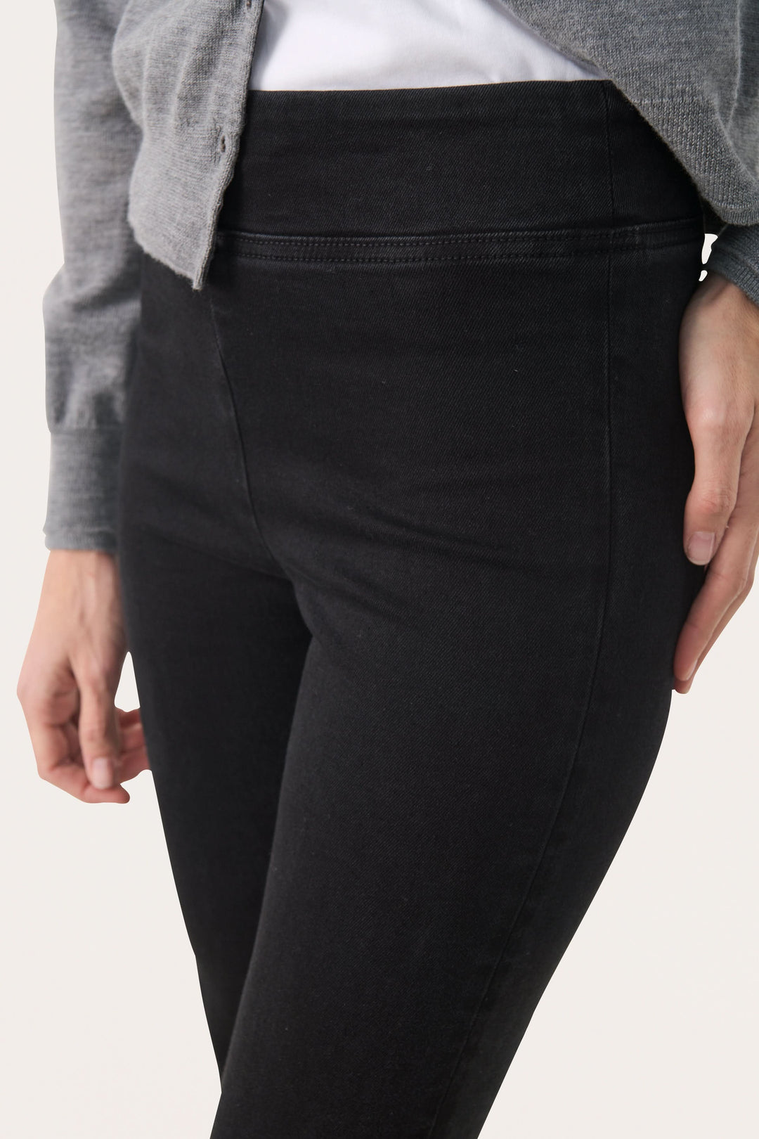 Pantalon Nikela noir avec taille haute élastiquée et jambe évasée, confort moderne et silhouette élancée.