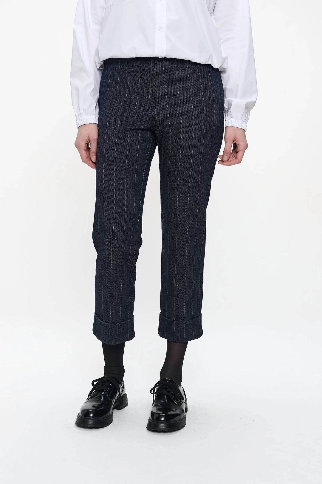 Pantalon Parrot avec rayures verticales, coupe ajustée, longueur 7/8, porté avec une chemise blanche.