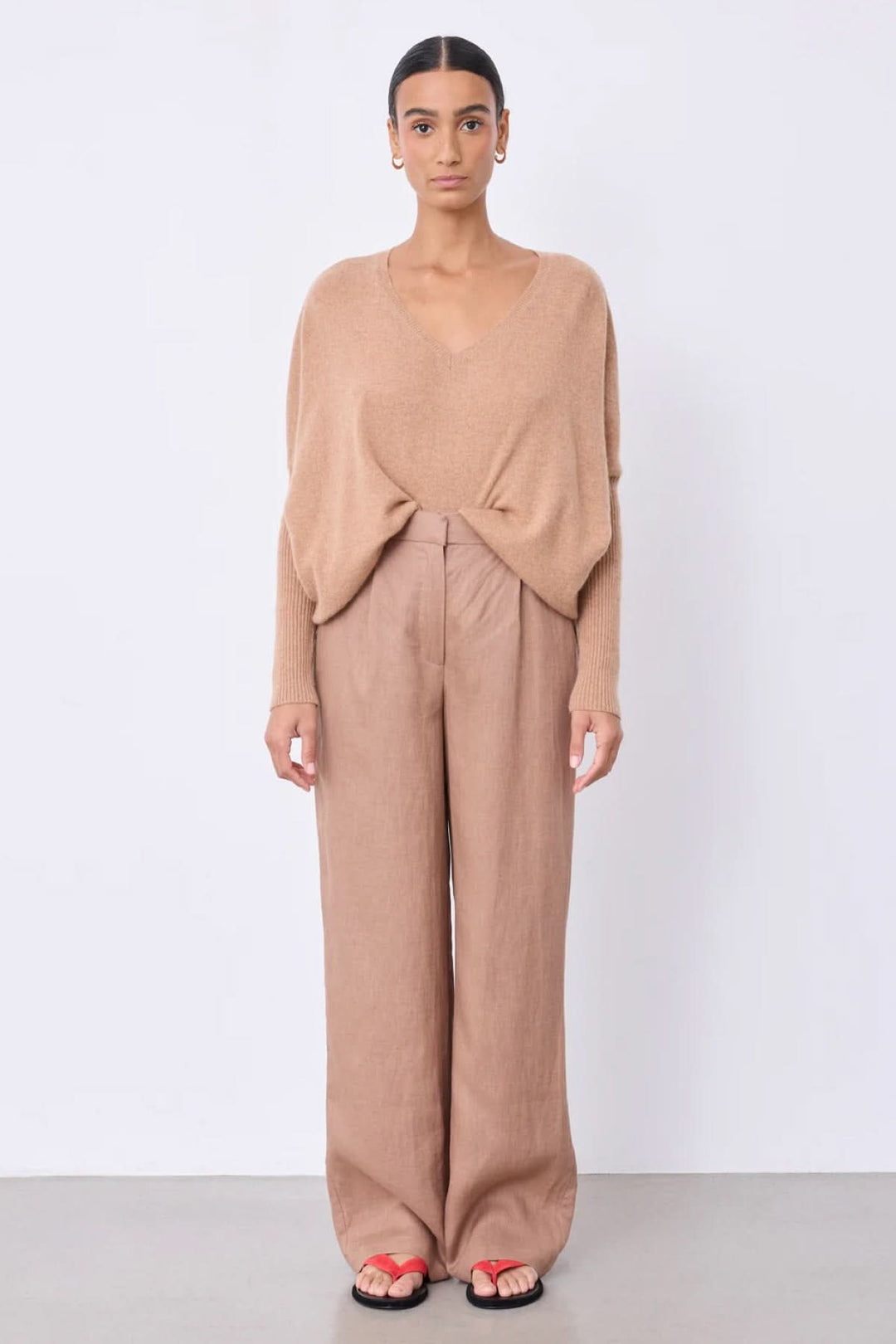 Pantalon Paula large fluide taille haute, élégant et confortable, porté avec un tricot léger, idéal pour un style chic décontracté.