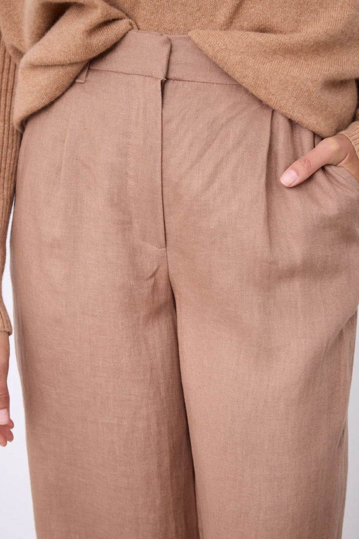 Pantalon Paula large fluide taille haute avec tissu fluide et poches idéales pour un style chic décontracté. Décris moi le produit en français.