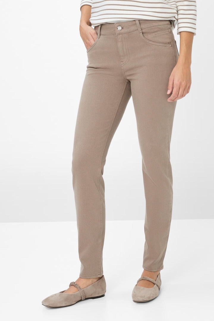 Femme portant le Pantalon Shakira ajusté marron, élégant et confortable, associé à un haut rayé pour un style chic. Taille mi-haute.