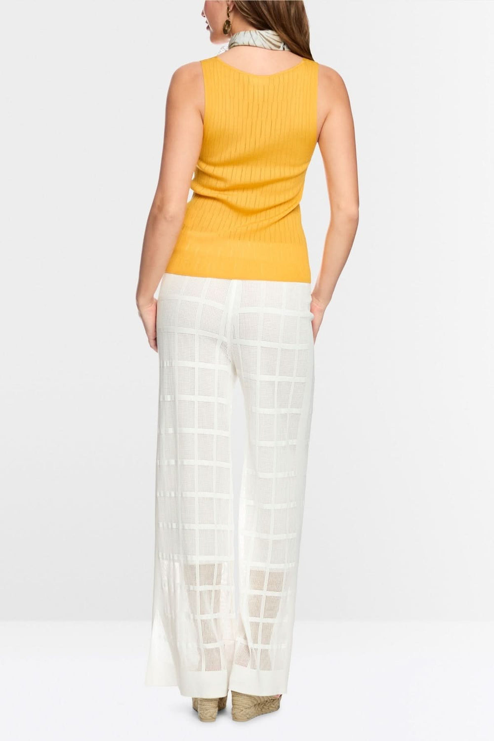 Femme portant un Pantalon Welkom large en maille ajourée avec un haut jaune, vue de dos.