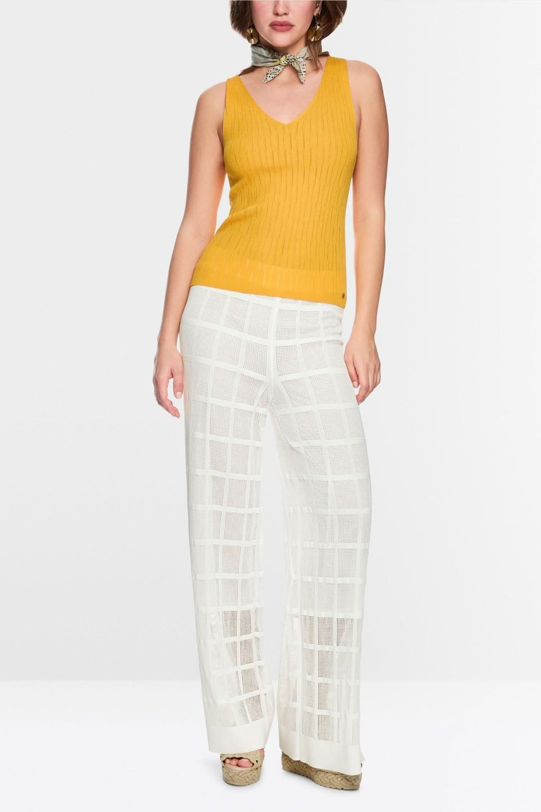 Pantalon Welkom large en maille ajourée, coupe fluide, semi-transparent, élégant et moderne, présenté par un mannequin debout.