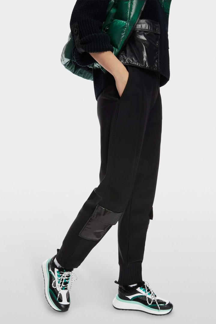Pantalon noir avec poches en nylon et empiècements côtelés, style décontracté, look utilitaire.