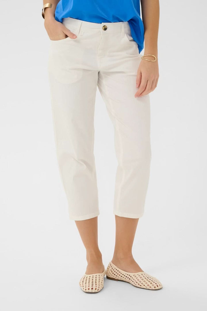 Pantalon capri Berta coupe droite en tissu blanc, longueur mi-mollet avec poches avant et fermeture à bouton visible.