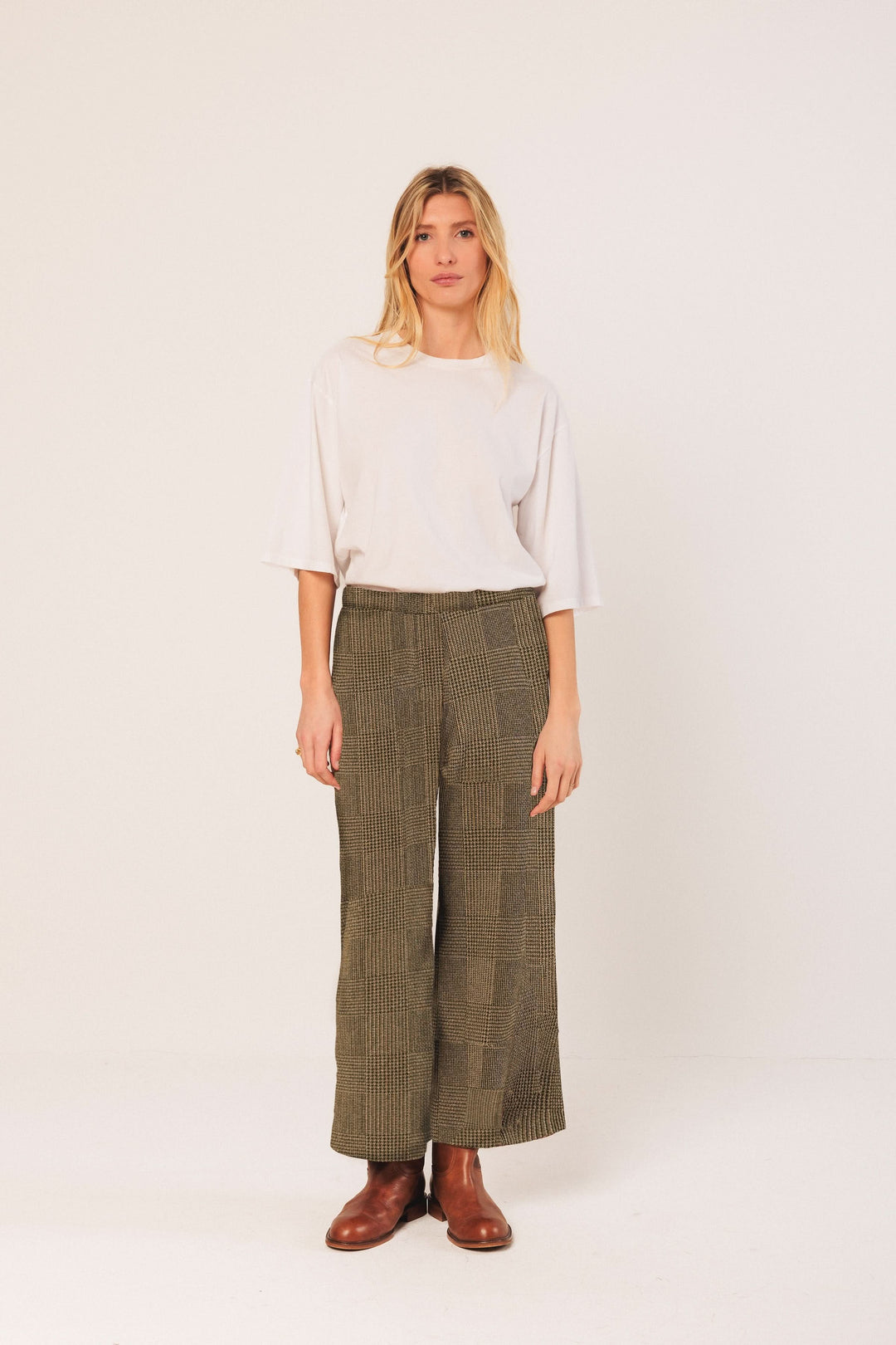 Pantalon à carreaux large et fluide porté avec un t-shirt blanc, combinaison moderne et confortable.