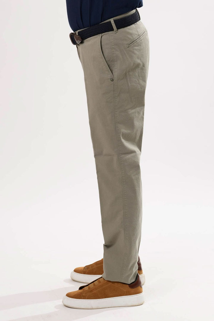 Pantalon chino à la coupe droite, léger et confortable, porté avec une ceinture et des sneakers.