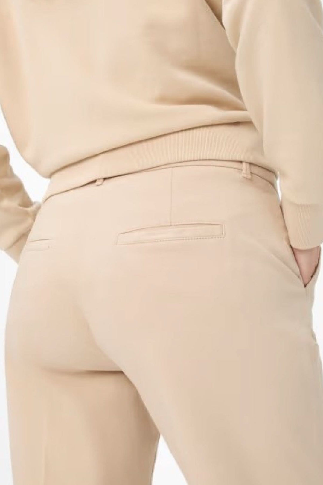 Pantalon chino Maron beige, coupe droite, détails de poches et confort optimal, porté avec un pull beige.
