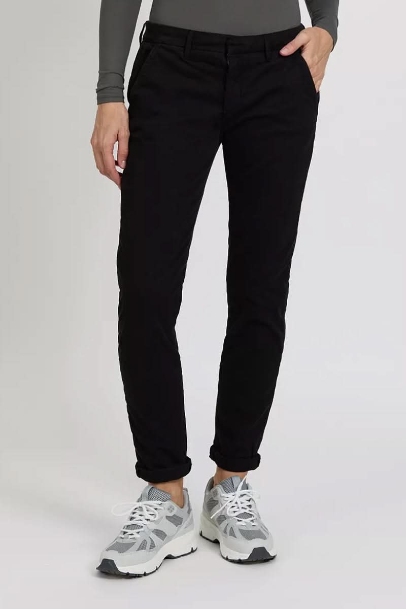 Pantalon chino Sandy noir porté avec des sneakers, mettant en avant une coupe élégante et décontractée.