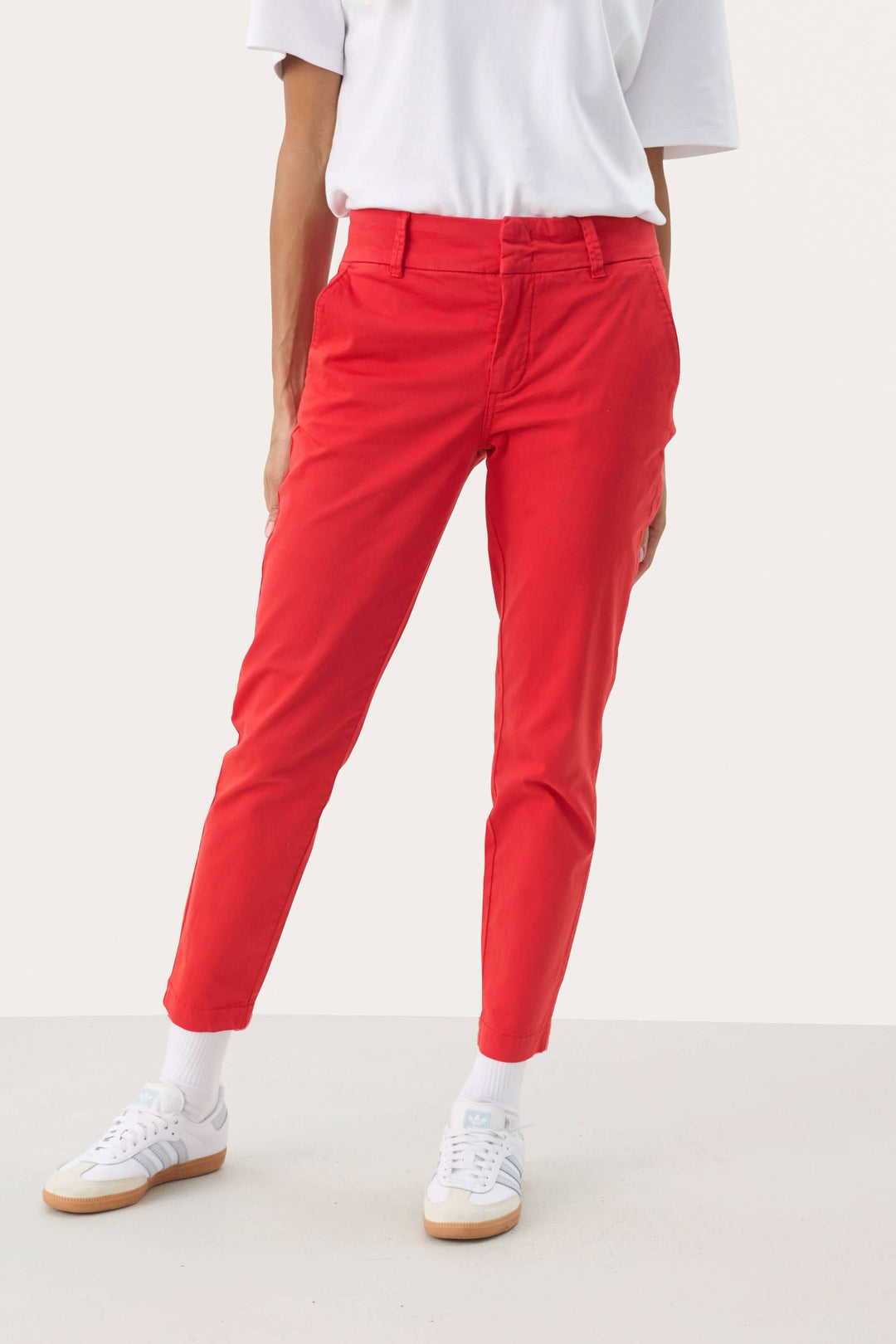 Pantalon chino rouge Soffys à coupe droite, avec taille classique et poches, porté avec un t-shirt blanc.