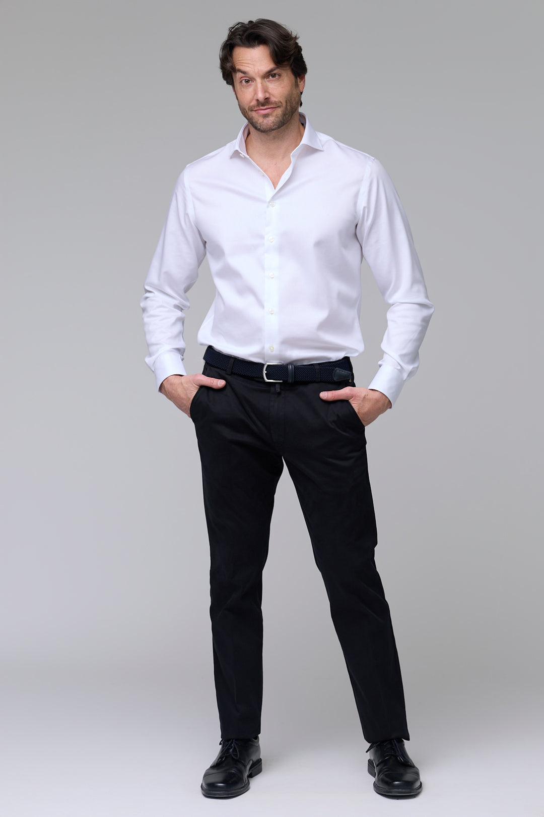Homme portant un pantalon chino ajusté noir avec chemise blanche, mettant en valeur un style professionnel et décontracté.