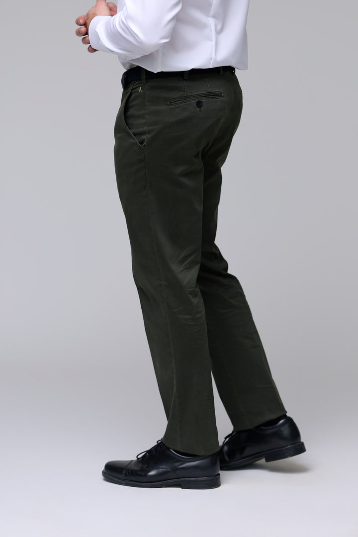 Homme portant un pantalon chino ajusté en tissu extensible avec chemise blanche, confort et style décontracté-professionnel.