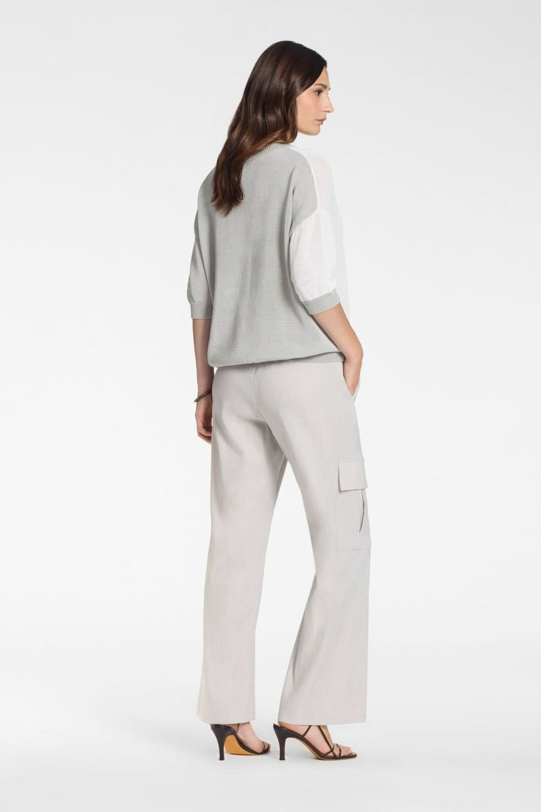 Femme portant un pantalon chino droit à poche cargo, coupe moderne et décontractée, longueur cheville.