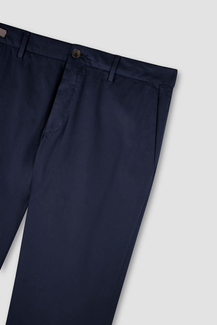 Pantalon chino en coton et soie extensible bleu marine sur fond gris, accent sur la qualité du tissu et la coupe élégante.