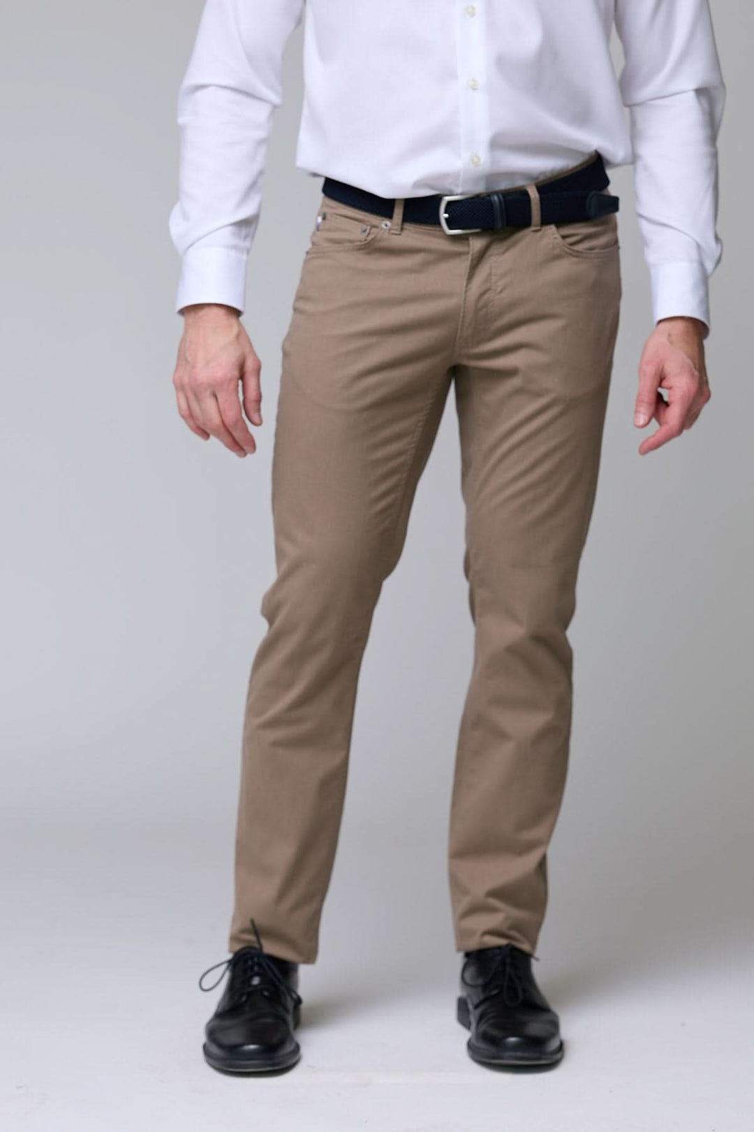 Pantalon chino extensible en tissu doux, coupe ajustée, idéal pour bureau ou sorties décontractées, porté avec chemise blanche.