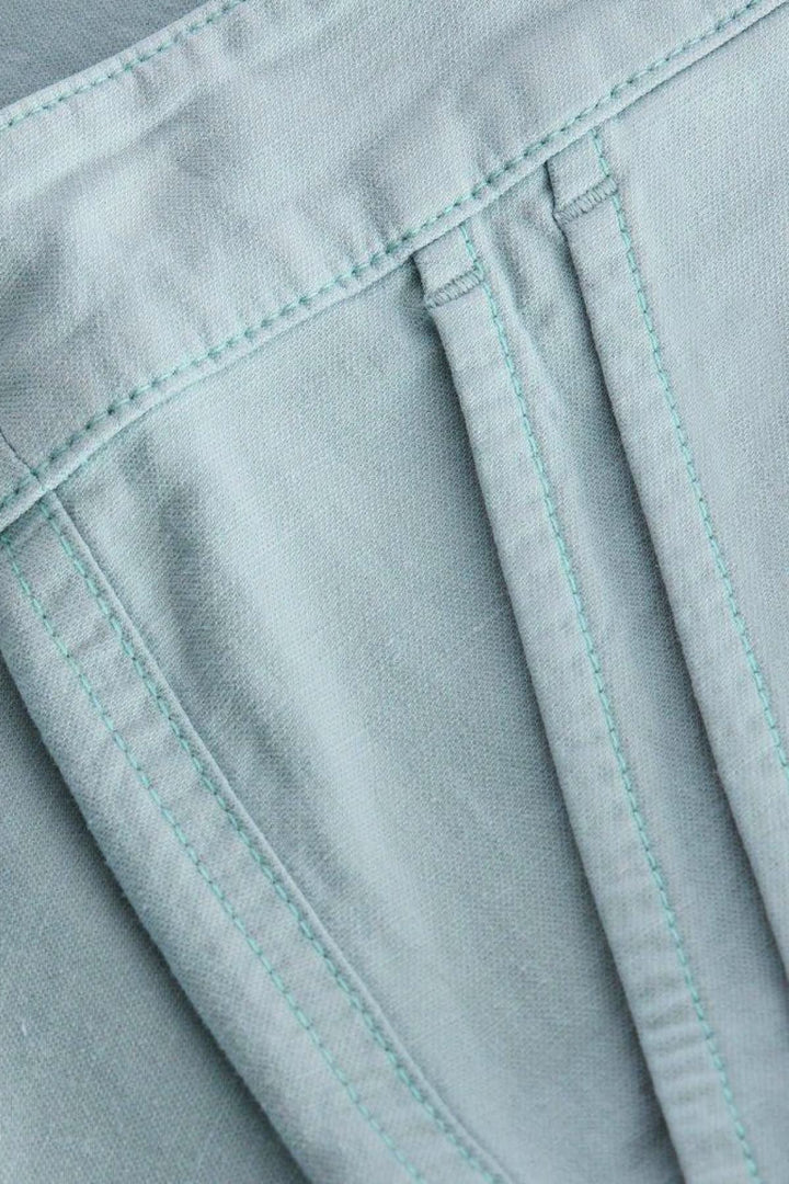 Zoom sur le tissu du pantalon chino long Twister bleu clair avec détails de couture.