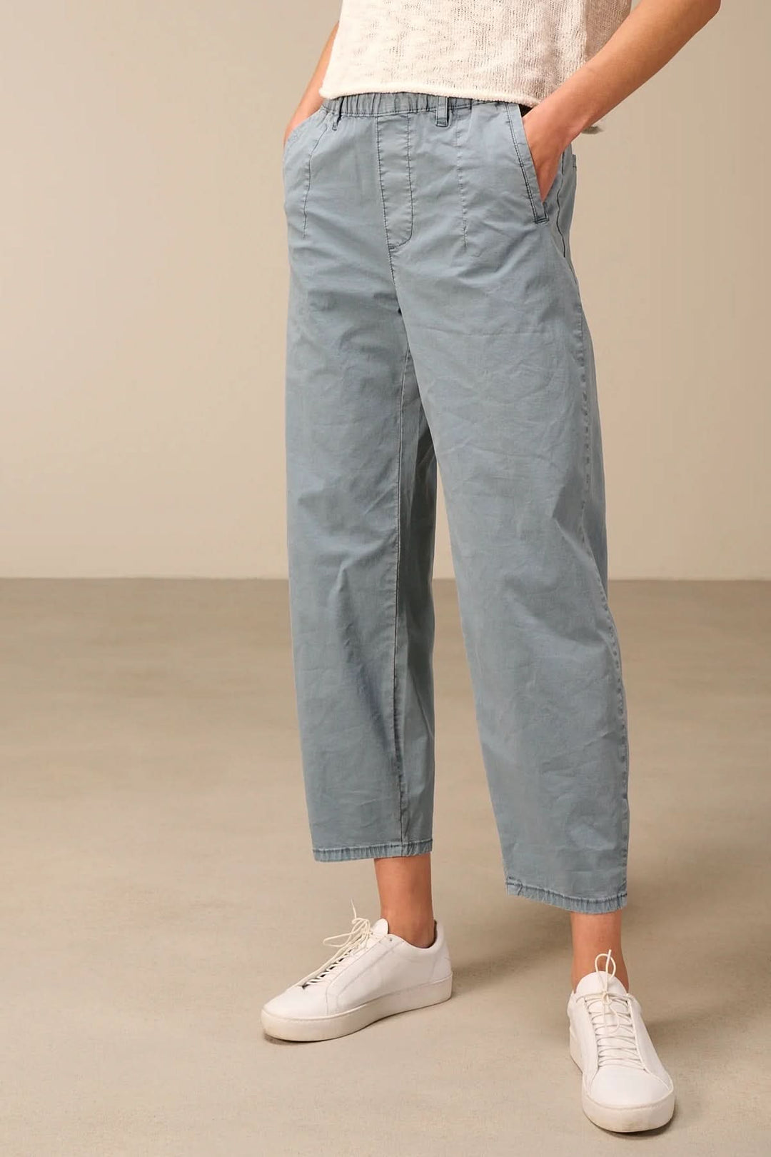 Pantalon à coupe décontractée avec taille élastique, tissu léger bleu, poche latérale, parfait pour un look casual ou habillé.