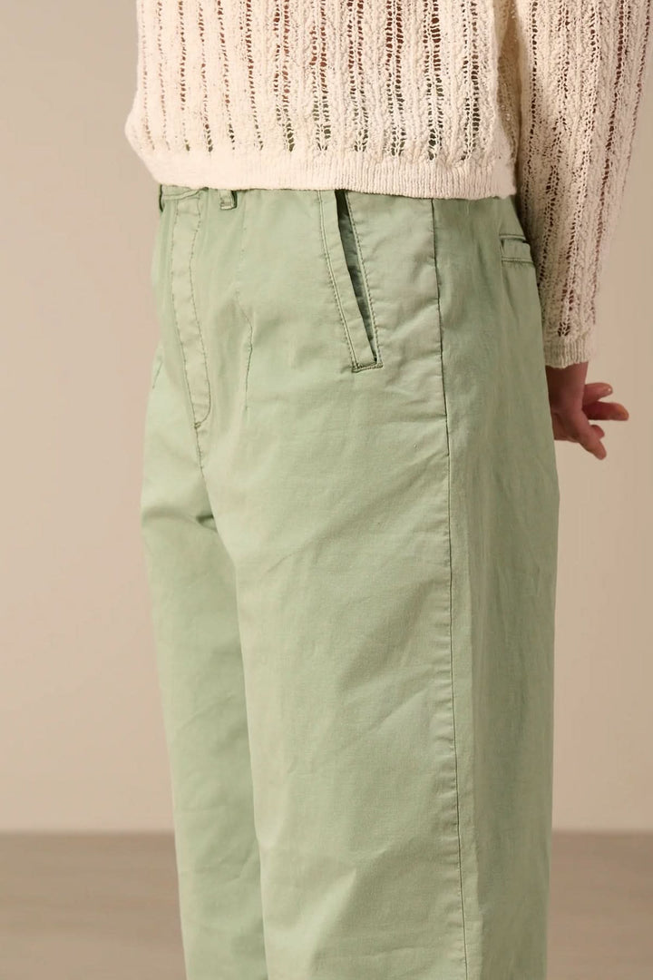 Pantalon à coupe décontractée avec taille élastique vert, détail des poches et fermeture pour un style moderne et confortable.