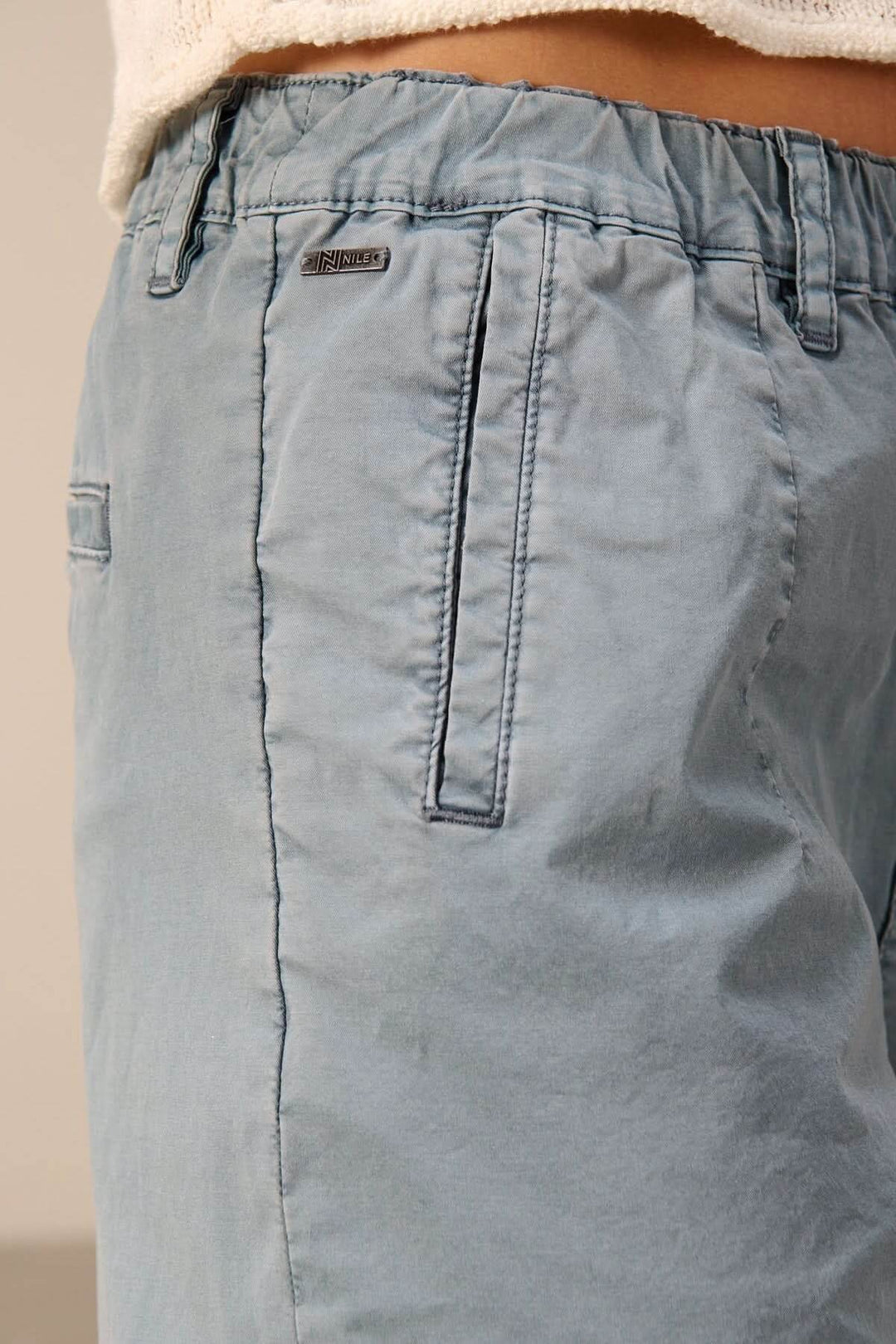 Pantalon à coupe décontractée avec taille élastique, vue de côté montrant les poches et la taille confortable pour un style moderne.