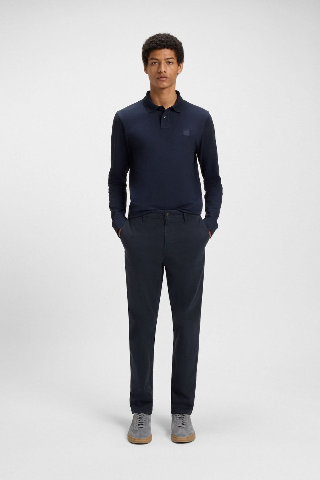 Homme portant un polo bleu marine et un pantalon fuselé, prêt pour un look élégant et décontracté.