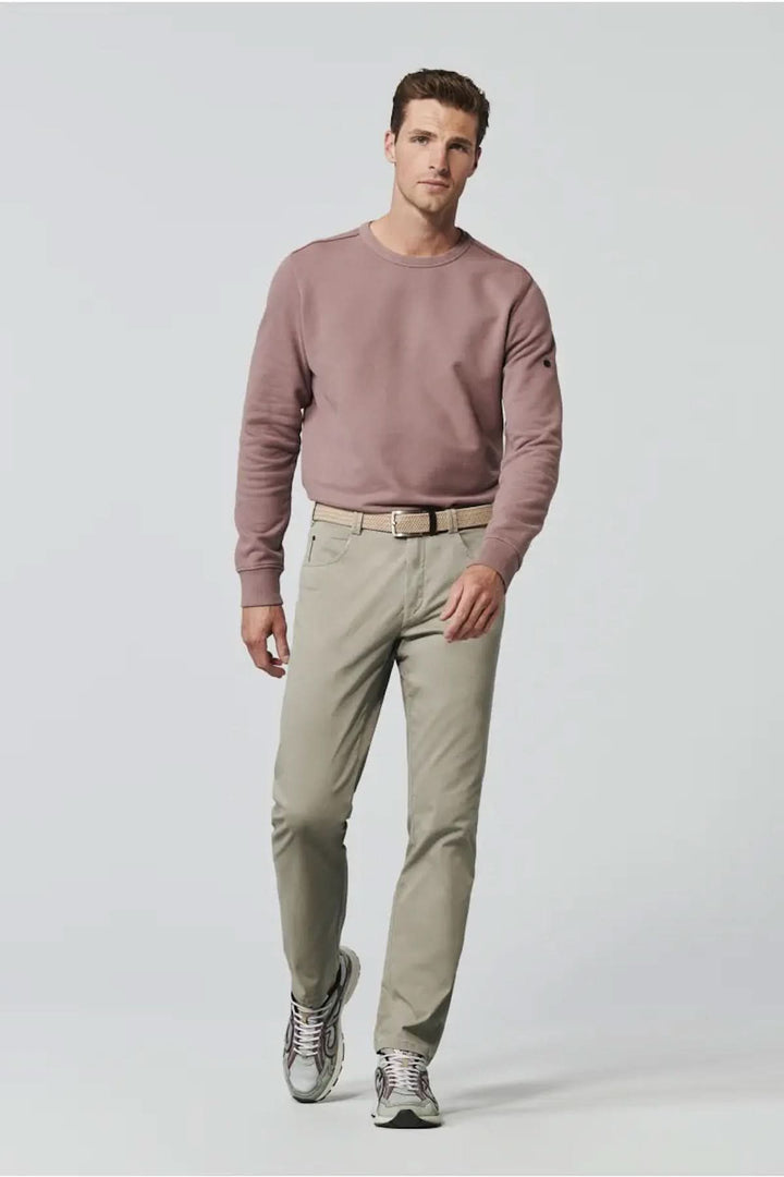 Homme portant un pantalon décontracté ajusté avec un chandail rose, style moderne, pour un look urbain.