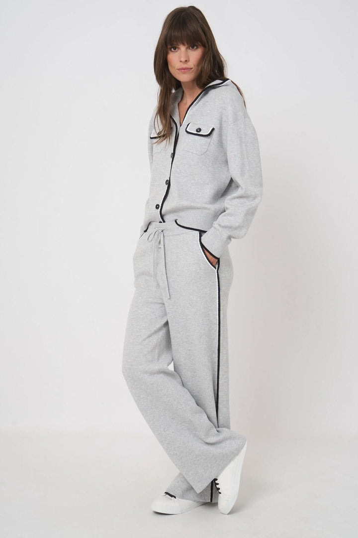 Femme portant un pantalon détente en tricot gris avec une coupe fluide et taille élastique, idéal pour un look casual moderne.