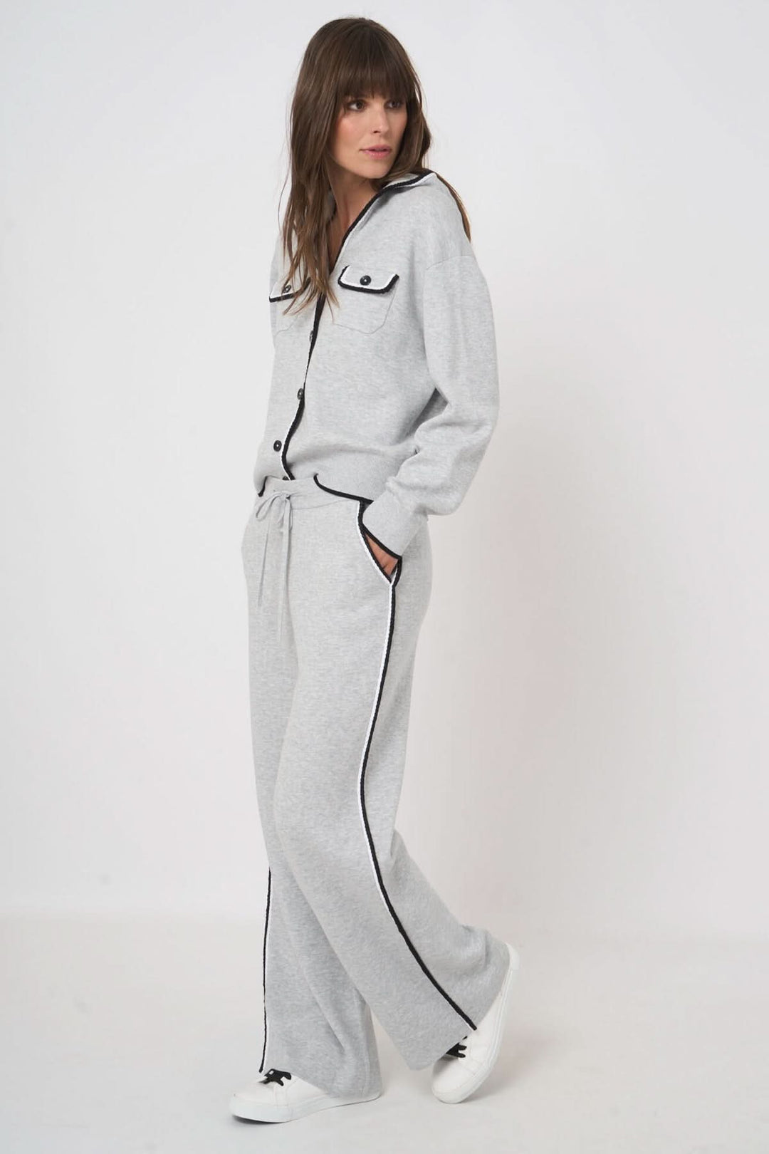 Femme portant un pantalon détente en tricot gris avec taille élastique et poches latérales, look casual moderne.