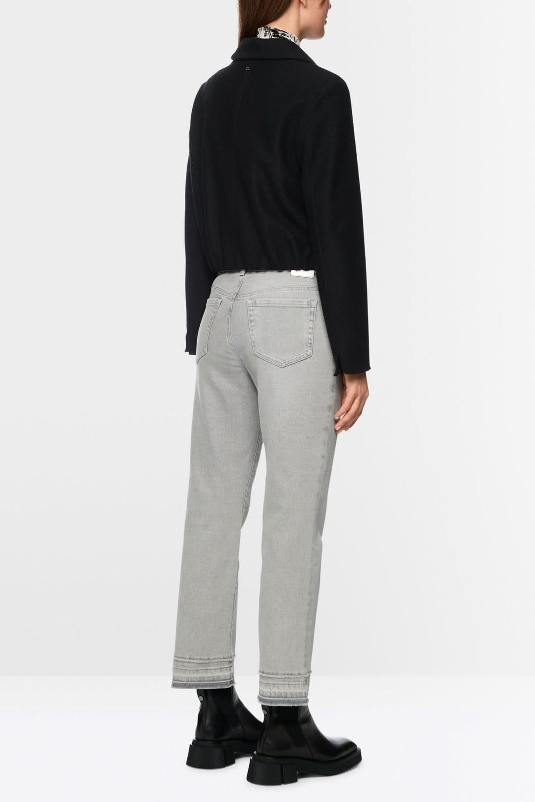 Pantalon en denim à coupe droite, légèrement évasée, avec effet effiloché au bas, style moderne et décontracté, vue arrière.