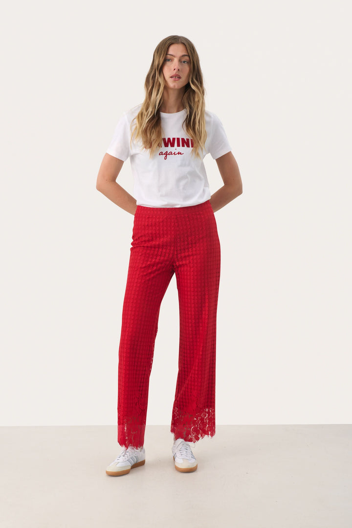 Pantalon en dentelle rouge à motif pied-de-poule, alliant élégance et sophistication.