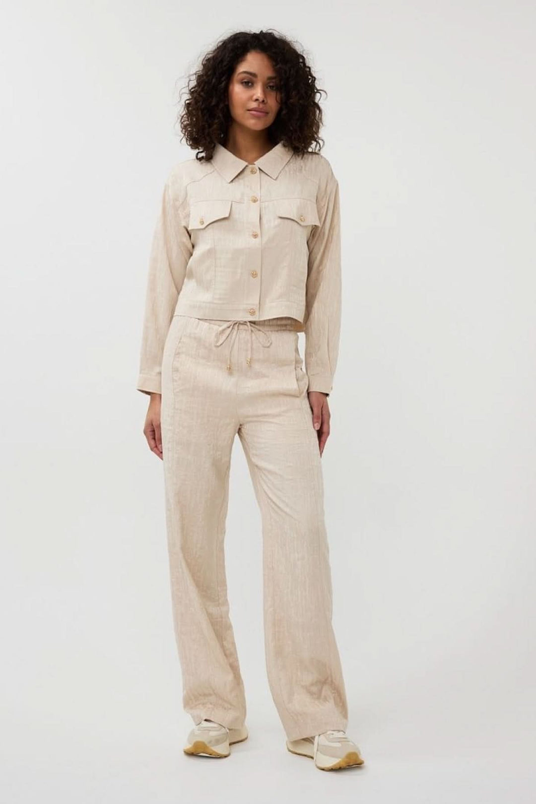 Pantalon ample en jacquard texturé beige avec veste assortie, style décontracté et moderne.
