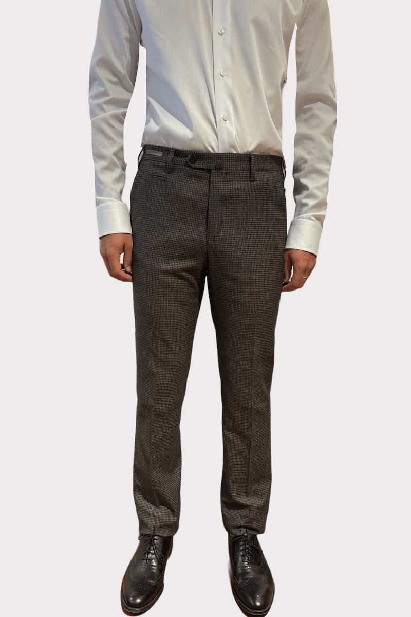 Pantalon en laine à carreaux, coupe ajustée, élégant et confortable, porté avec une chemise blanche.