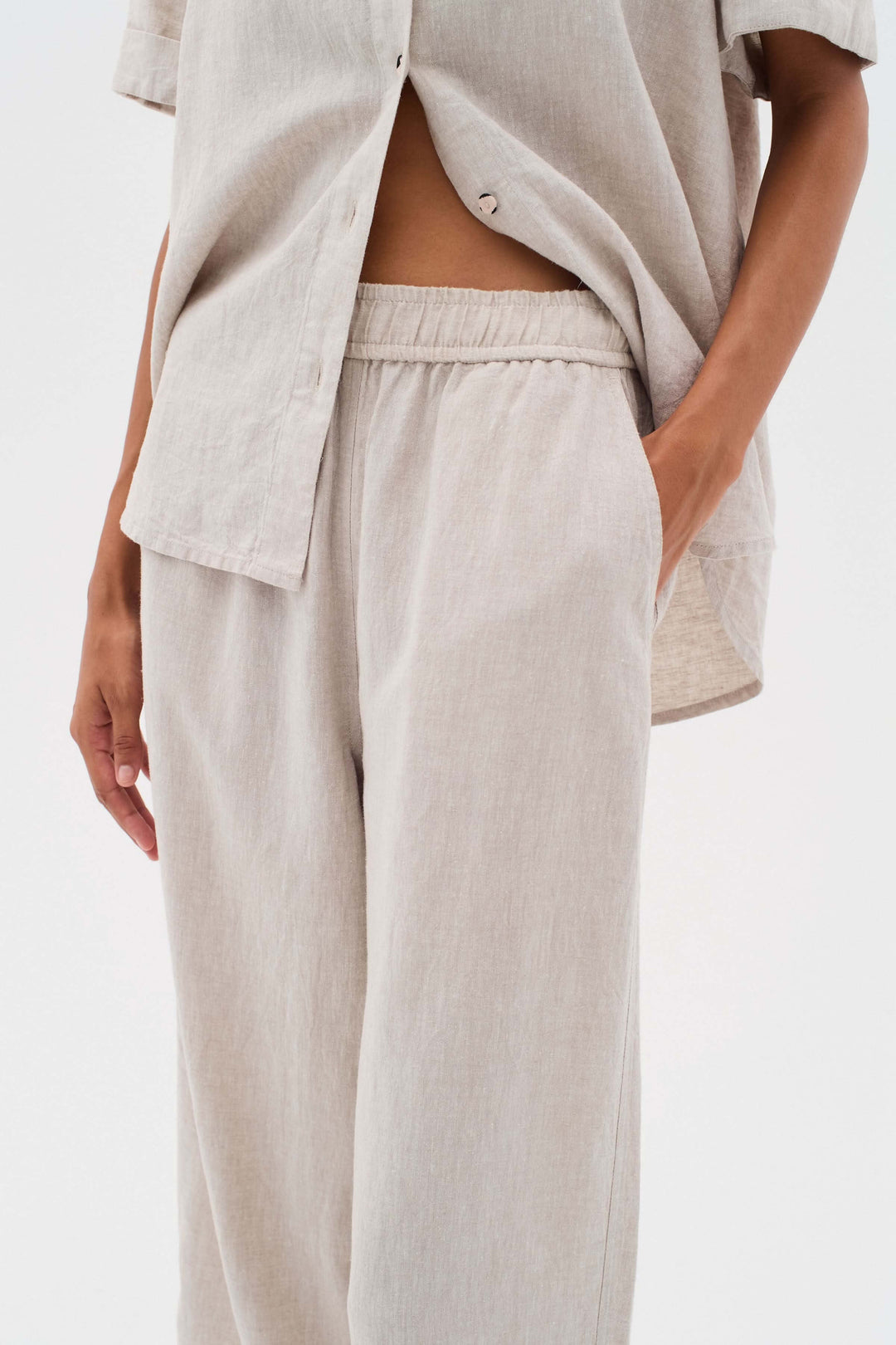 Pantalon en lin léger avec taille élastique et poches, alliant confort et élégance.