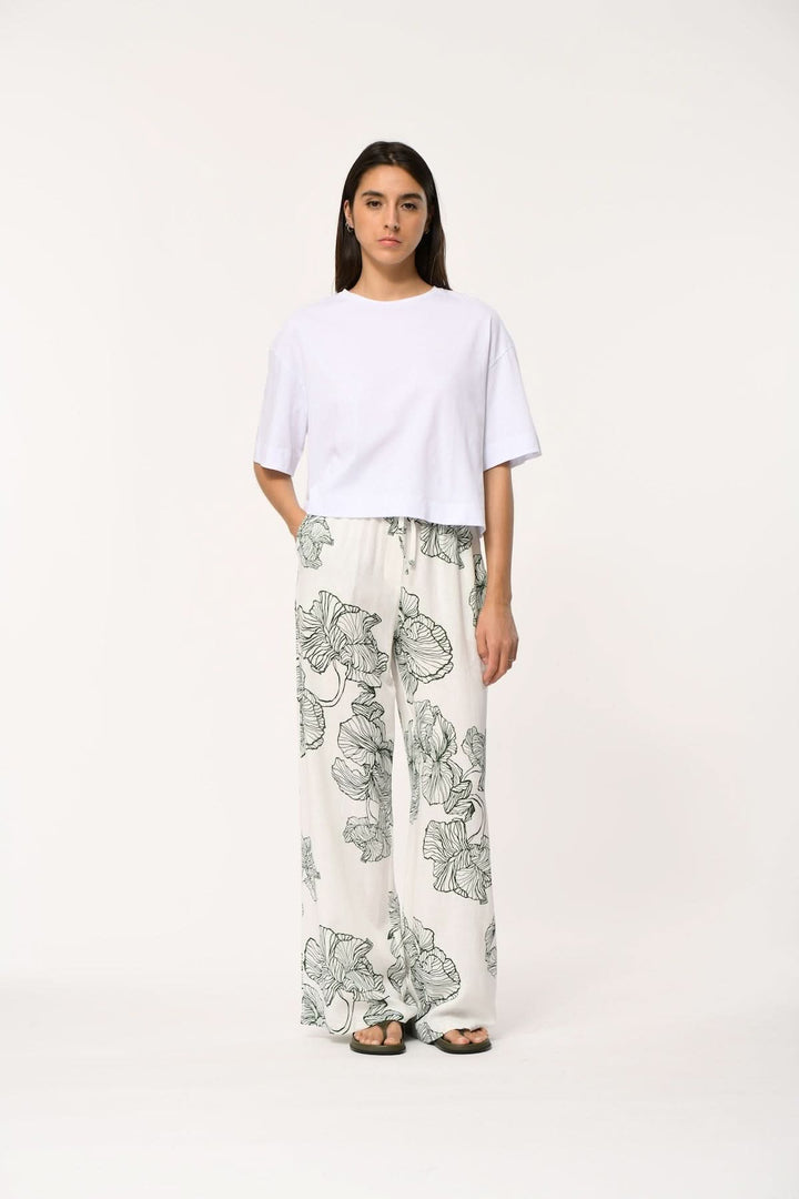 Modèle portant un pantalon fluide imprimé à coupe large JAKOTA avec haut blanc, mettant en valeur le confort et le design artistique.