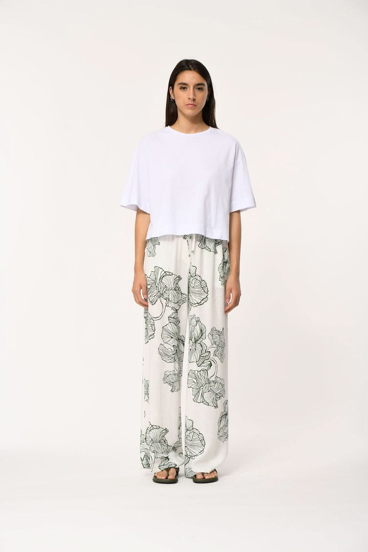 Pantalon fluide imprimé à coupe large JAKOTA porté avec un haut blanc, imprimé délicat et coupe large offrant confort et élégance.