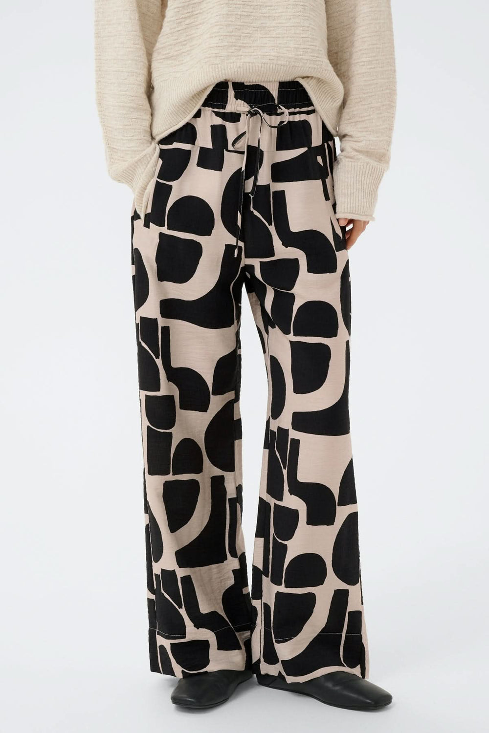 Pantalon fluide motif abstrait Lynn à jambe large avec taille élastique et poches, offrant un style moderne et décontracté.