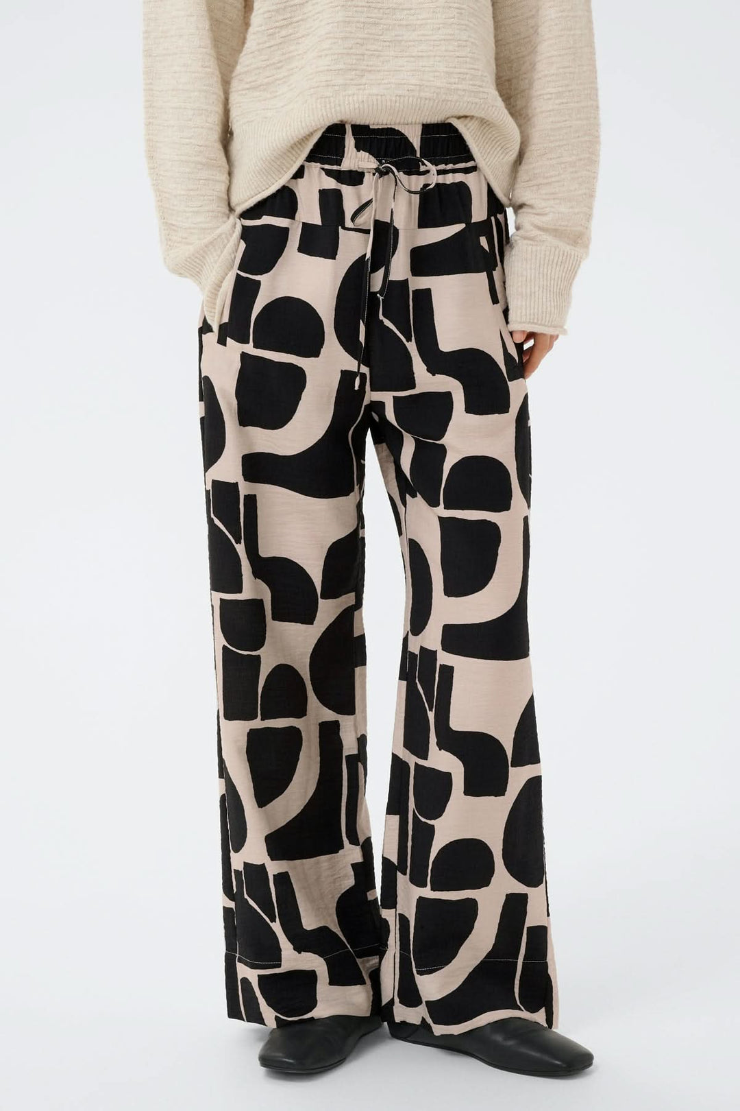 Pantalon fluide motif abstrait Lynn à jambe large avec taille élastique et poches, offrant un style moderne et décontracté.