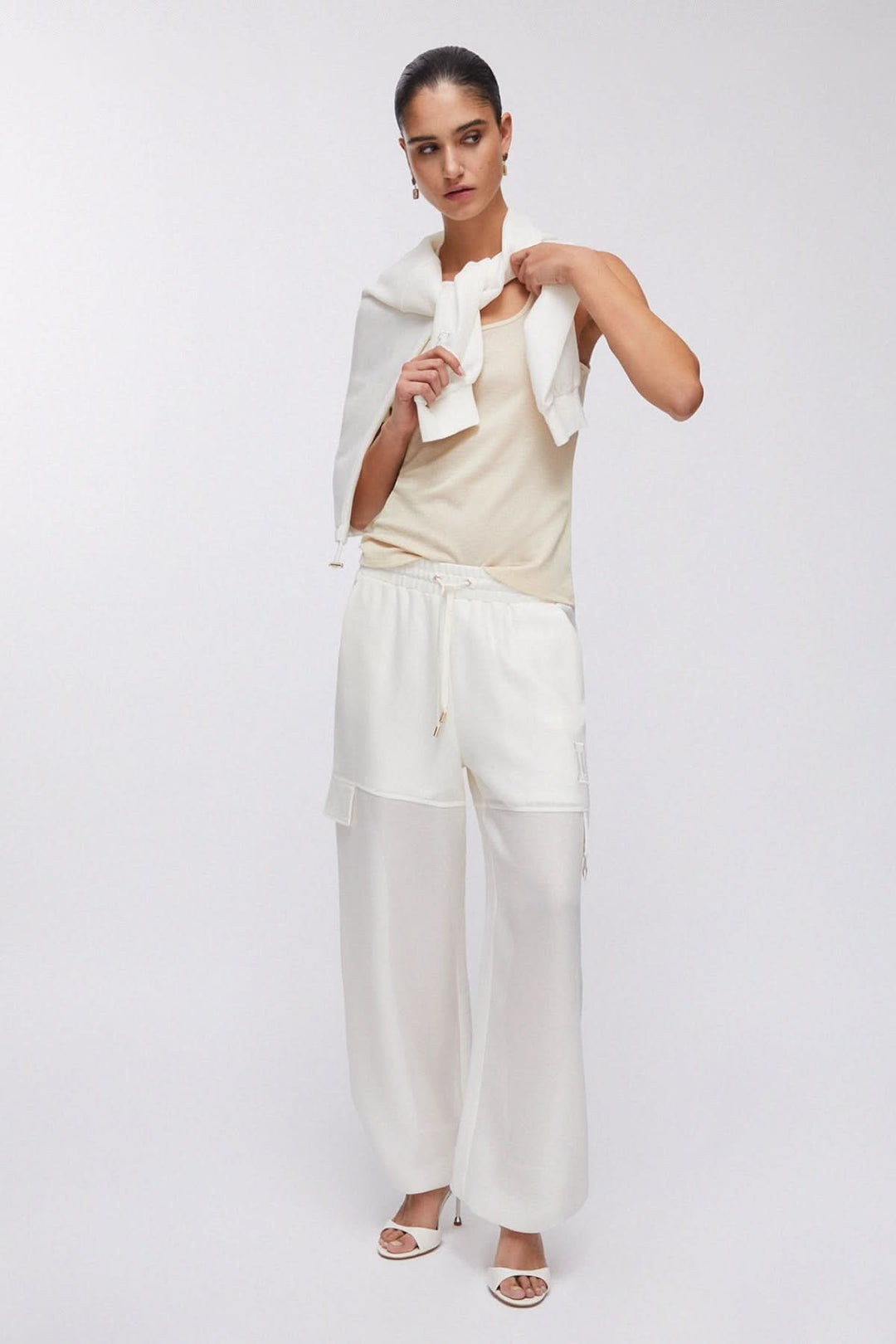 Pantalon jogging large à cordon blanc porté pour un look décontracté et moderne, avec une taille élastique et des poches latérales.
