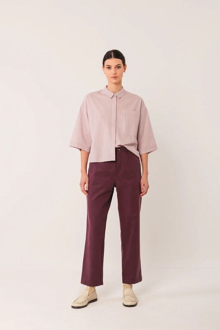Modèle portant un pantalon droit bordeaux avec taille mi-haute, style moderne et confortable, idéal avec chemise ou chandail.